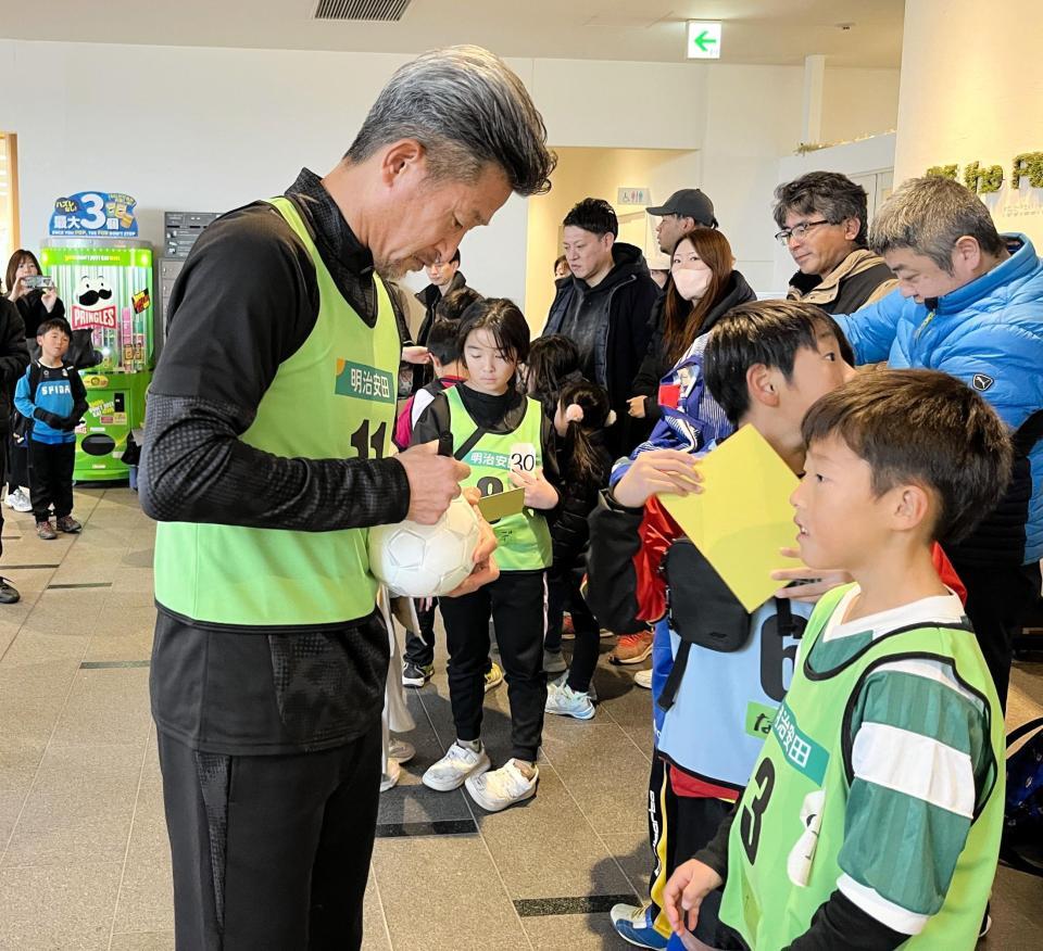 　参加者のサインに応じるカズ