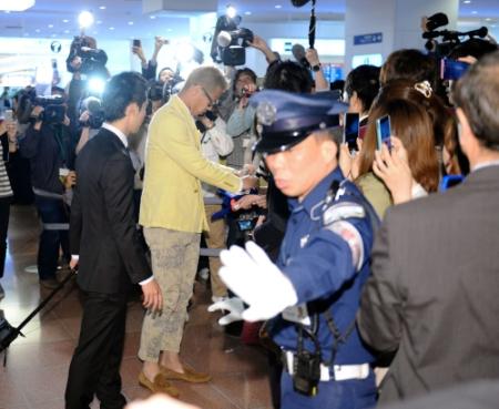 到着ロビーで大勢の報道陣とファンに迎えられサインをする本田圭佑(中央)=羽田空港(撮影・開出 牧)