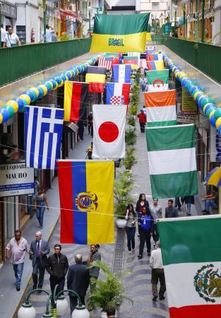 サッカーW杯開幕直前、出場国の国旗で彩られたサンパウロ市内の商店街=9日(共同)