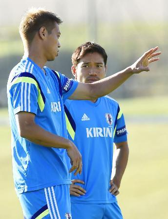 コートジボワール戦に向けた練習で、長友(奥)と話す本田=イトゥ(共同)