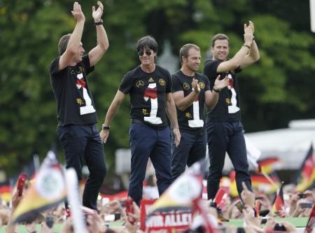 　１５日、ベルリンで、サポーターにＷ杯ブラジル大会の優勝を報告するレーウ監督（左から２人目）ら（ＡＰ＝共同）