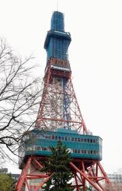 　補修工事のため、一部が青いネットで覆われた「さっぽろテレビ塔」＝２２日午前、札幌市