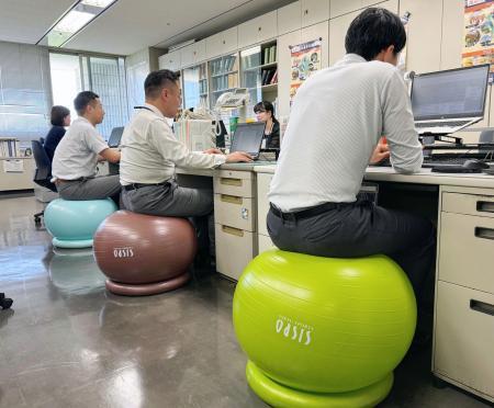 　職員がバランスボールに座って業務する実証実験が始まった福岡市役所＝１４日午前