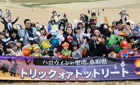 　鳥取砂丘で開かれたハロウィーンパーティーで、記念撮影する参加者＝２７日午前、鳥取市