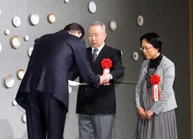 　「２０２５年　シチズン・オブ・ザ・イヤー」に選ばれ表彰を受ける置田和永さん（中央）と起美さん（右）夫妻＝２９日午前、東京都千代田区