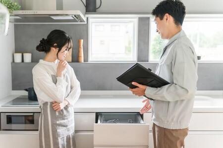 キッチンで食洗器の説明を受ける女性※画像はイメージです（buritora/stock.adobe.com）