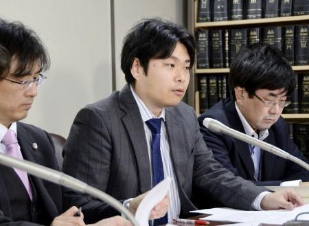 　提訴後に記者会見する中沢佑一弁護士（中央）ら＝１８日午後、東京・霞が関の司法記者クラブ