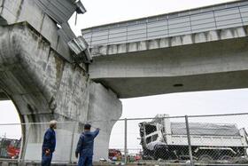 　大阪府羽曳野市の南阪奈道路で、高架の壁を突き破って転落したダンプカー＝７日午後１時４７分