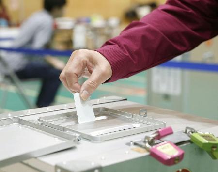 　投票箱に１票を投じる有権者