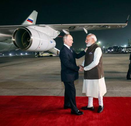 　インドのモディ首相（右）と握手するロシアのプーチン大統領＝４日、ニューデリー（インド外務省提供、共同）