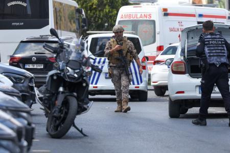 　銃撃事件の現場付近を歩く警察官ら＝７日、トルコ・イスタンブール（ロイター＝共同）