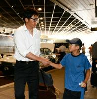 ファンの子どもと握手する阪神・新井貴浩=新千歳空港(撮影・園田高夫)