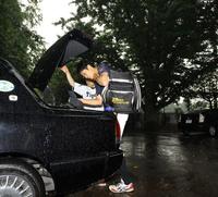 激しい雨の中、タクシーに荷物を詰め込む藤浪(撮影・棚橋慶太)