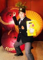 縁起物の「勝栗」を手にスローイングの構えを見せる阪神ドラフト4位指名の福岡大・梅野(撮影・辰巳直之)