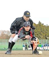 中学生の背後に立ち、低い捕球姿勢を徹底させる掛布DC(撮影・佐々木彰尚)