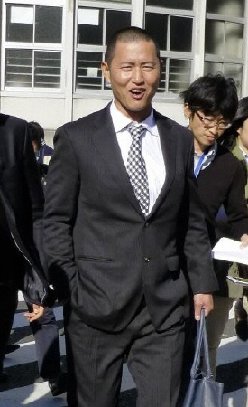 阪神への移籍が決まった鶴岡は報道陣に囲まれて球団事務所を後にする＝横浜市内