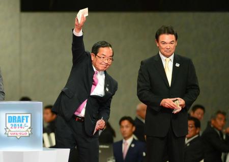 　早大・有原の交渉権を獲得し高々と手を掲げる日本ハム・津田社長（左）とは対照的に渋い表情の和田監督