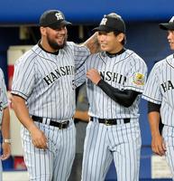　ゴメス（左）に今季初勝利を祝福され、笑顔を見せる岩崎