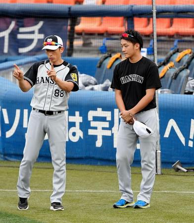 試合前に矢野コーチ（左）から指示を受ける松田