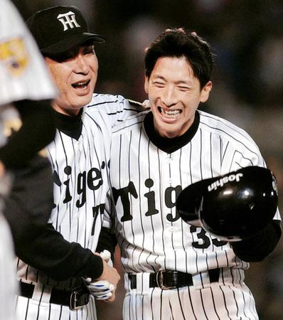 　横浜戦で逆転サヨナラ三塁打を放ち、星野監督（左）に迎えられる矢野＝２００３年６月１７日