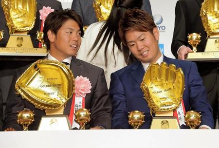 　三井ゴールデン・グラブ賞を受賞して賞品のゴールデングラブを見つめる阪神・西。左は梅野＝都内のホテル