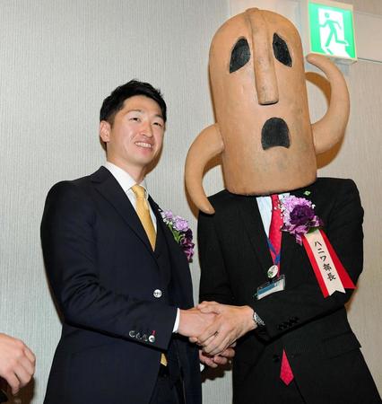 共に関西元気文化圏賞を受賞したハニワ部長（右）とガッチリ握手を交わす近本（撮影・高部洋祐）