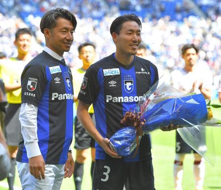 　試合前、Ｇ大阪の昌子（右）に花束を贈る鳥谷敬氏（撮影・吉澤敬太）