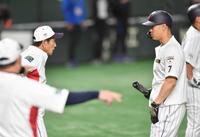　４日、打撃練習で栗山監督（左）と話す佐藤輝