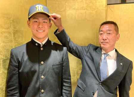 　仮契約を終え、笑顔を見せる阪神５位指名の天理・戸井零士（左）＝阪神タイガース提供