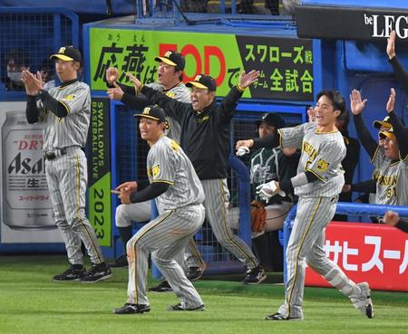 　９回、佐藤輝の二塁打でベンチを飛び出して喜ぶ岡田監督（中央）ら阪神ナイン＝２４日