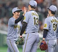 　巨人に勝利し、（右から）中野、岩崎とタッチを交わす近本（撮影・中田匡峻）