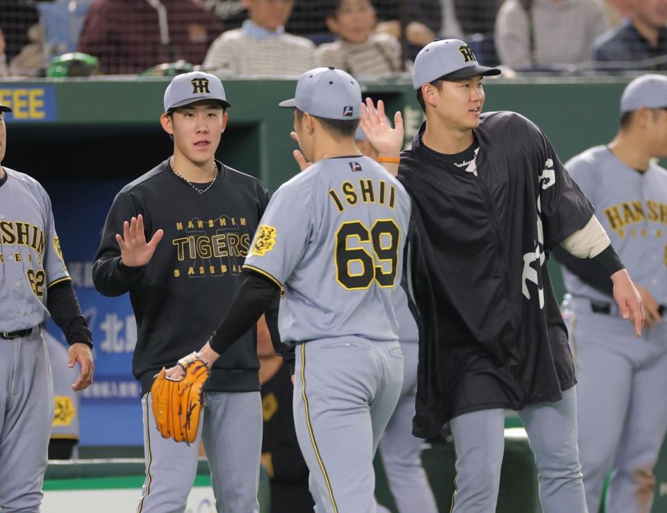 ７回、及川（右）と並んで石井を迎える富田（左）＝撮影・西岡正