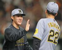 　今季初勝利を挙げた富田（左）は藤川監督とタッチを交わす（撮影・中田匡峻）