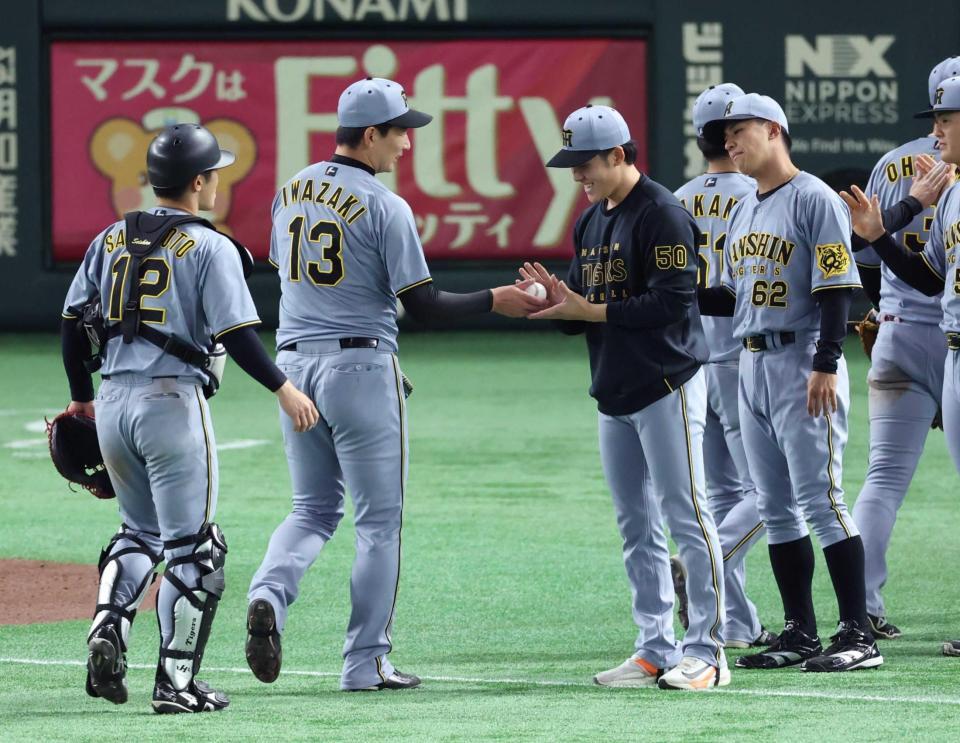 　阪神・岩崎　優からウイニングボールを受け取る阪神・富田蓮（撮影・金田祐二）