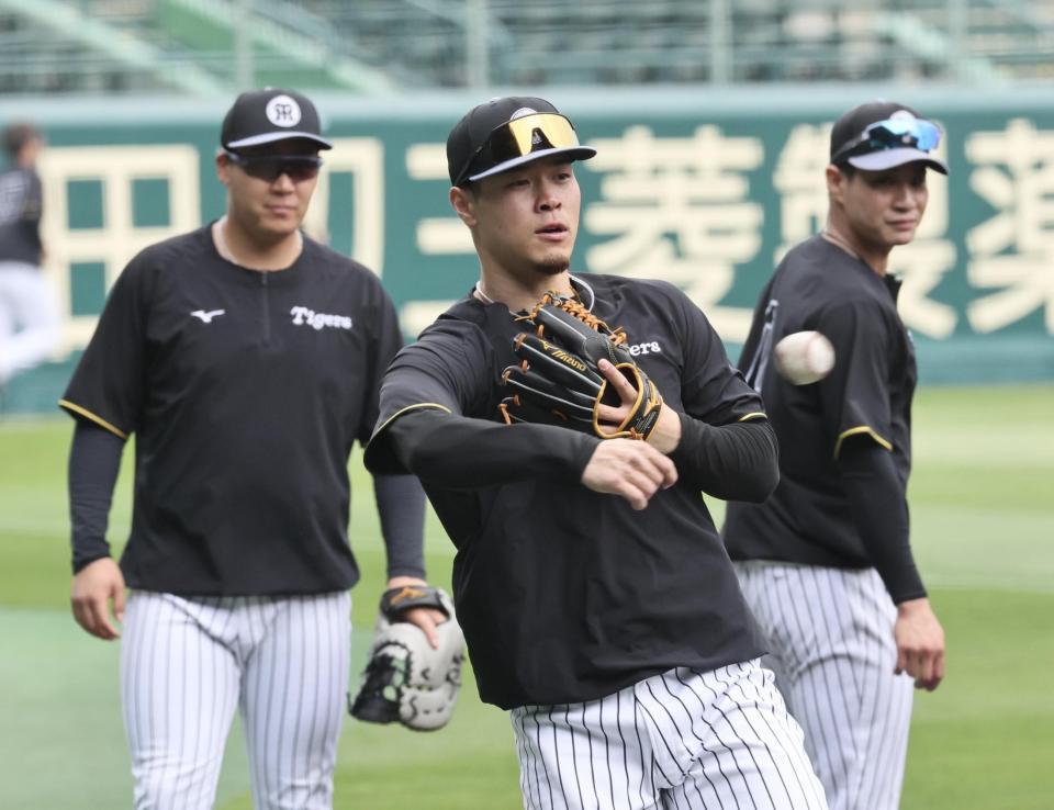 　大山（左後方）らと一緒にノックを受ける佐藤輝（撮影・田中太一）