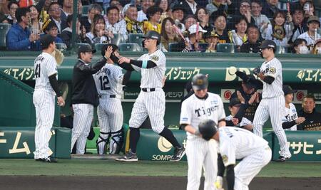 　１回、森下（手前）の同点２点適時打で生還した佐藤輝（中央）と中野（右）はナインとタッチを交わす（撮影・中田匡峻）