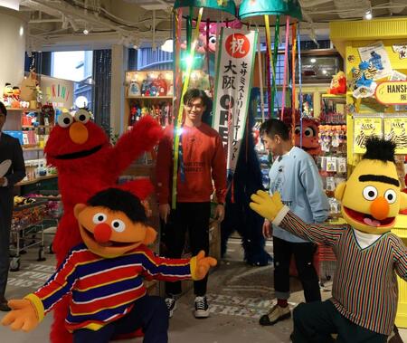 　セサミストリートマーケット阪神梅田本店のオープンを記念し、くす玉を割った湯浅（中央）は写真に納まる（撮影・北村雅宏）