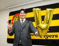 　契約を更改し、ポーズを決める及川（撮影・北村雅宏）