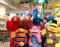　セサミストリートマーケット阪神梅田本店のオープンを記念し、写真に納まる（前列左から）アーニー、アビー、バート（後列左から）エルモ、湯浅、クッキーモンスター、ますだおかだ・増田（撮影・北村雅宏）