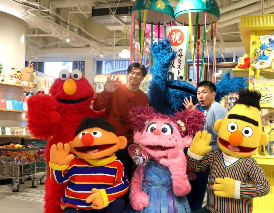 　セサミストリートマーケット阪神梅田本店のオープンを記念し、写真に納まる（前列左から）アーニー、アビー、バート（後列左から）エルモ、湯浅、クッキーモンスター、ますだおかだ・増田（撮影・北村雅宏）