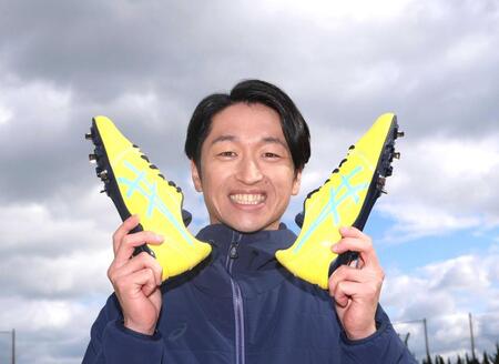 　スパイクを手に笑顔を見せる近本