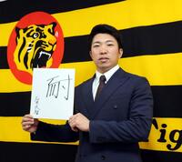 　今年の漢字「耐」を書いた色紙を手にする石井（撮影・山口登）