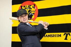 　入団会見でポーズを決める浜田（撮影・山口登）