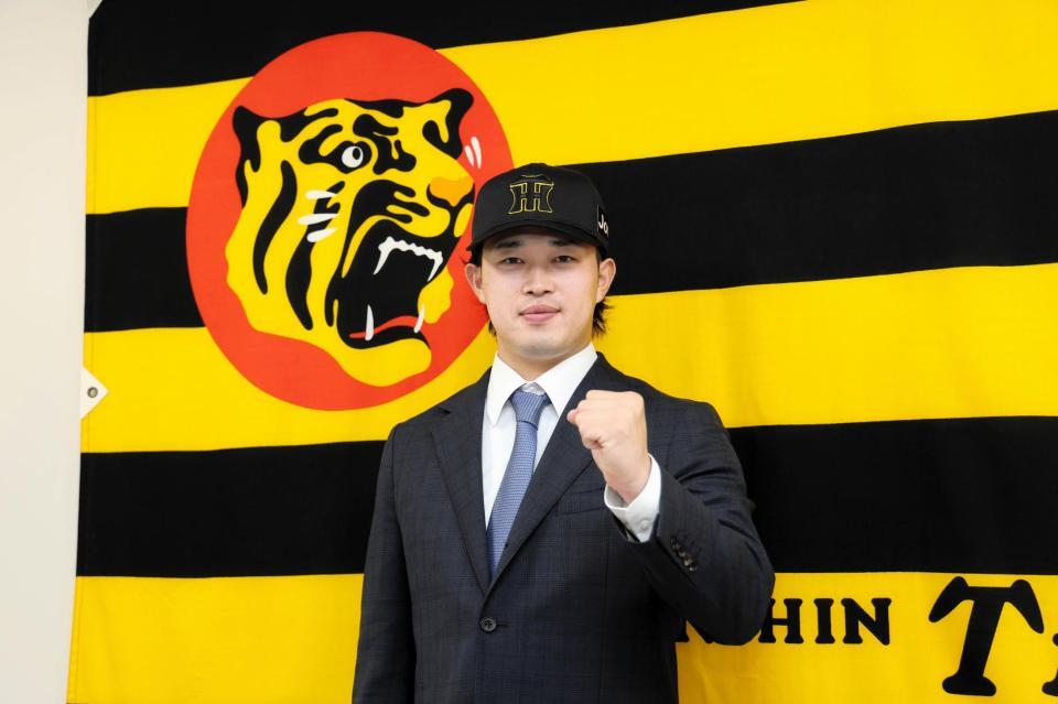 　入団会見でポーズを決める浜田（撮影・山口登）