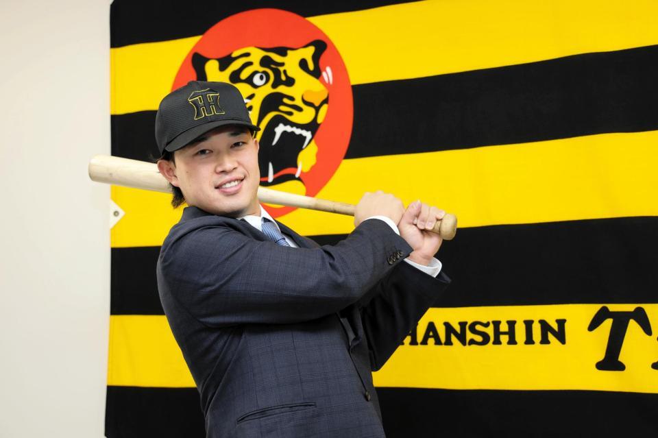 　入団会見でポーズを決める浜田（撮影・山口登）