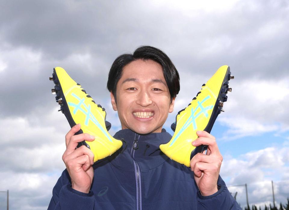 　スパイクを手に笑顔を見せる近本