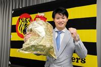 　契約を更改し、笑顔でポーズを決める（撮影・山口登）