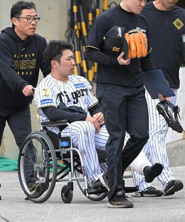 車いすで球場を後にする石井（撮影・飯室逸平）