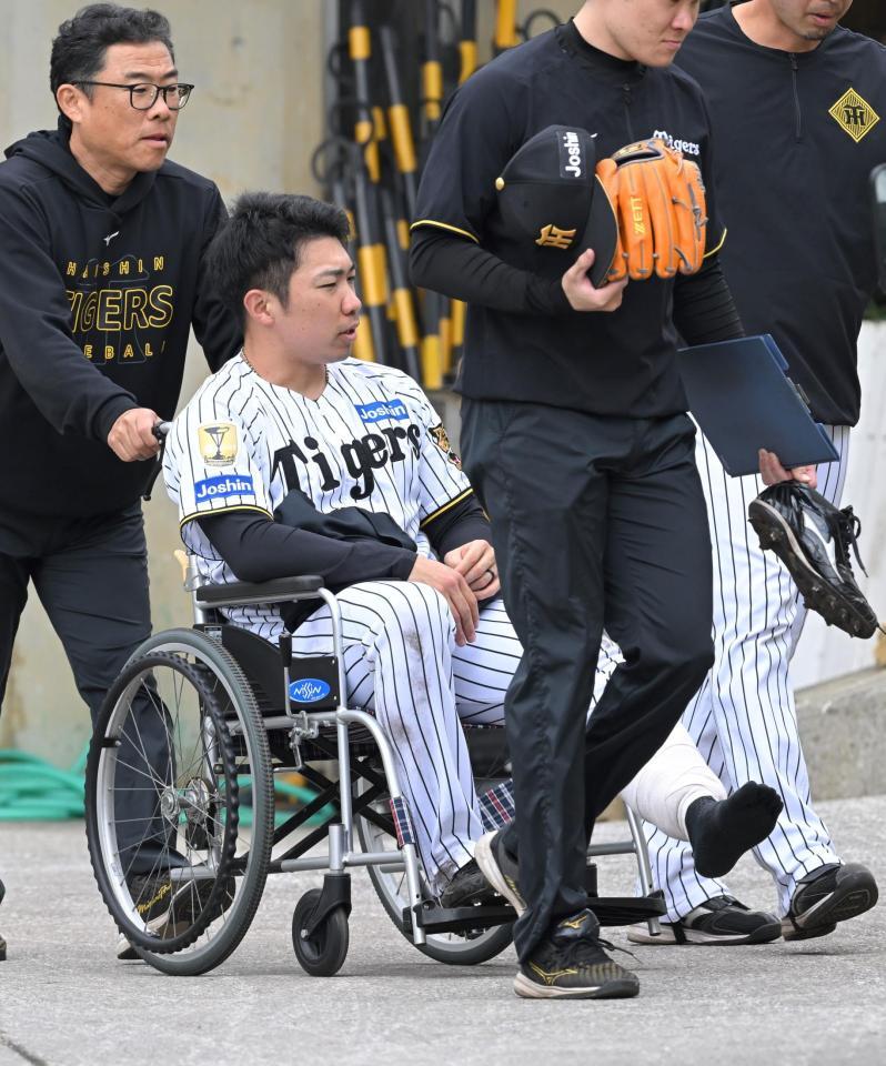 車いすで球場を後にする石井（撮影・飯室逸平）