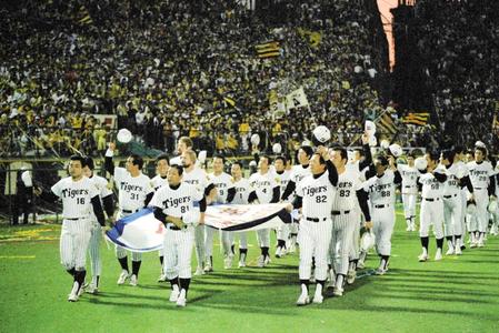 最終戦を終え、チャンピオンフラッグを手に　ファンの声援に応えながら行進する吉田義男監督（前列中央）、岡田彰布（同左）ら阪神ナイン＝１９８５年１０月２２日、甲子園球場